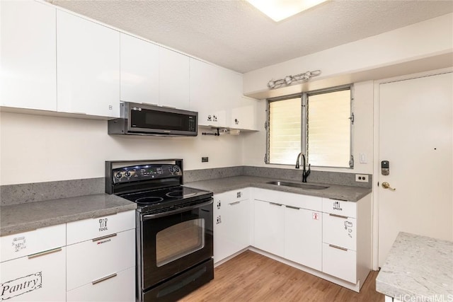 kitchen with light hardwood / wood-style floors, a textured ceiling, black electric range oven, white cabinetry, and sink