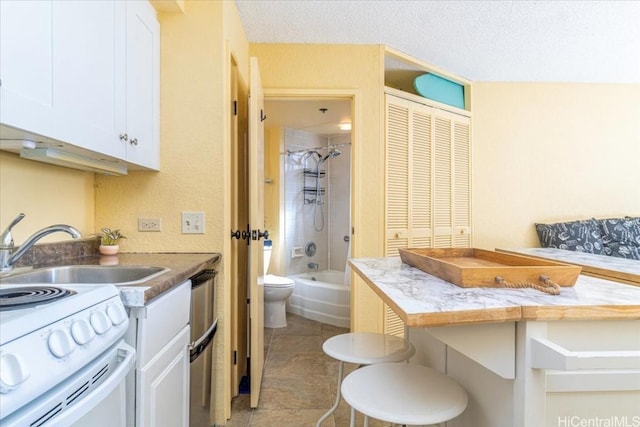 full bathroom with vanity, tile patterned floors, tiled shower / bath, toilet, and a textured ceiling