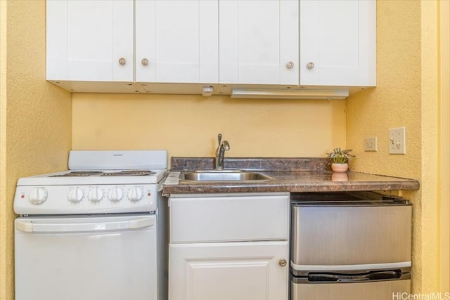 kitchen featuring white electric range oven, white cabinetry, and sink