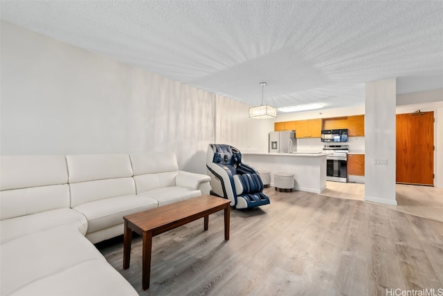 living room with light hardwood / wood-style flooring and a textured ceiling