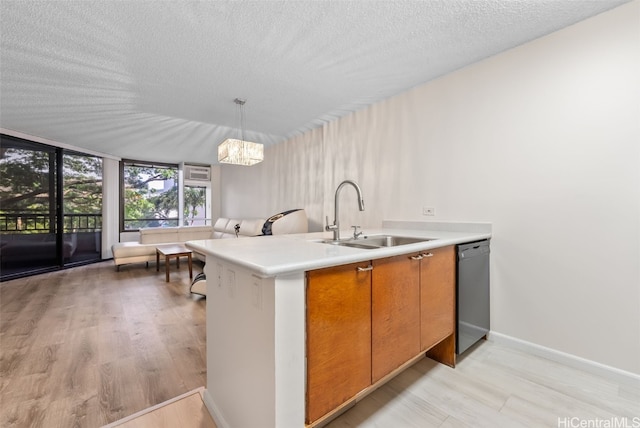 kitchen featuring pendant lighting, sink, black dishwasher, light hardwood / wood-style floors, and a textured ceiling