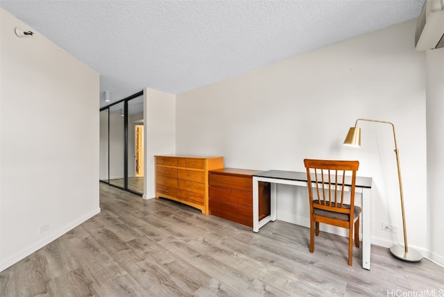 unfurnished office with a textured ceiling and light hardwood / wood-style flooring