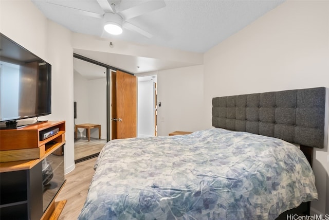 bedroom featuring ceiling fan, a textured ceiling, and light wood-type flooring