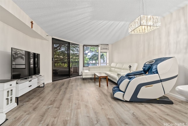 living room featuring a wall of windows, a textured ceiling, and light wood-type flooring