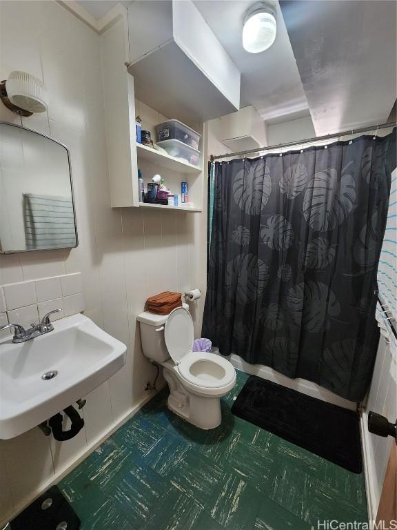 bathroom with decorative backsplash, sink, and toilet