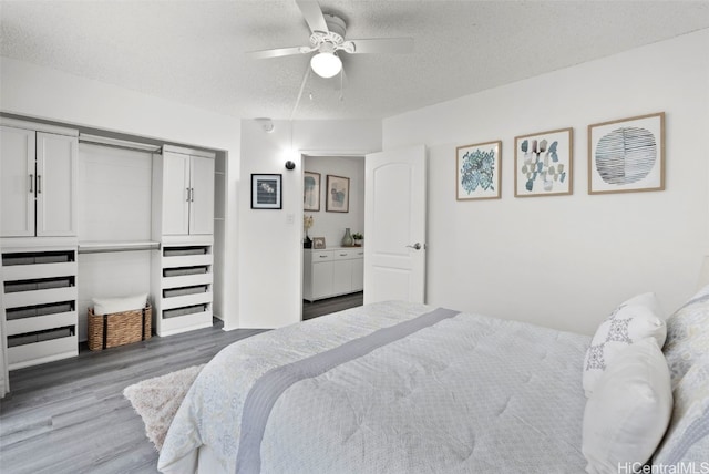 bedroom with dark hardwood / wood-style flooring, a textured ceiling, and ceiling fan