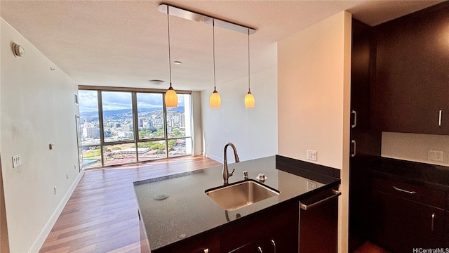 1189 Waimanu St Unit 3107, Honolulu, HI 96814 - kitchen featuring a sink, light wood-style floors, stainless steel dishwasher, baseboards, and pendant lighting