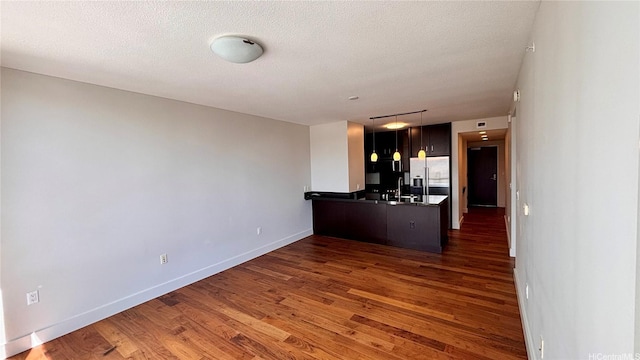 1189 Waimanu St Unit 3107, Honolulu, HI 96814 - kitchen featuring stainless steel fridge with ice dispenser, a peninsula, wood finished floors, baseboards, and a textured ceiling