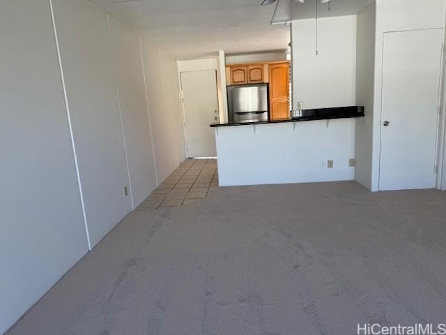 kitchen featuring light carpet and stainless steel refrigerator