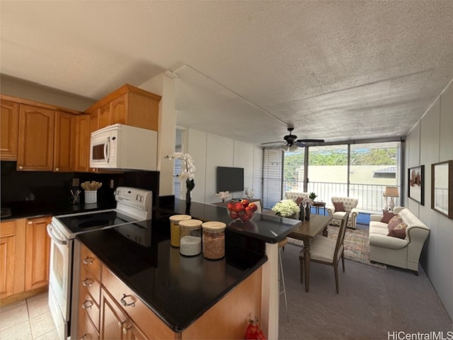 kitchen with ceiling fan, white appliances, and a textured ceiling