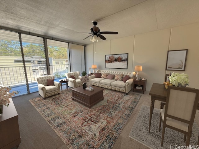 living room with ceiling fan, a wall of windows, and a textured ceiling