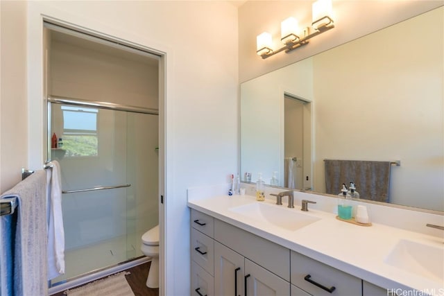 bathroom with walk in shower, vanity, and toilet