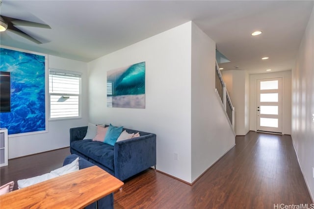 living room with ceiling fan and dark wood-type flooring