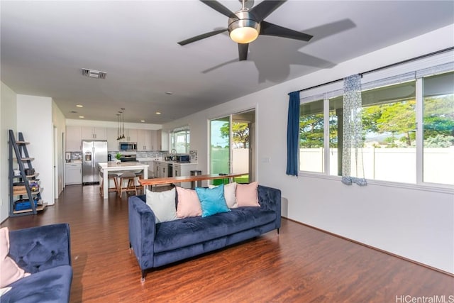 living room with ceiling fan and dark hardwood / wood-style flooring