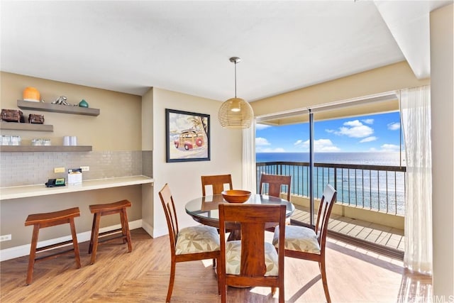 dining space with a water view and light parquet floors