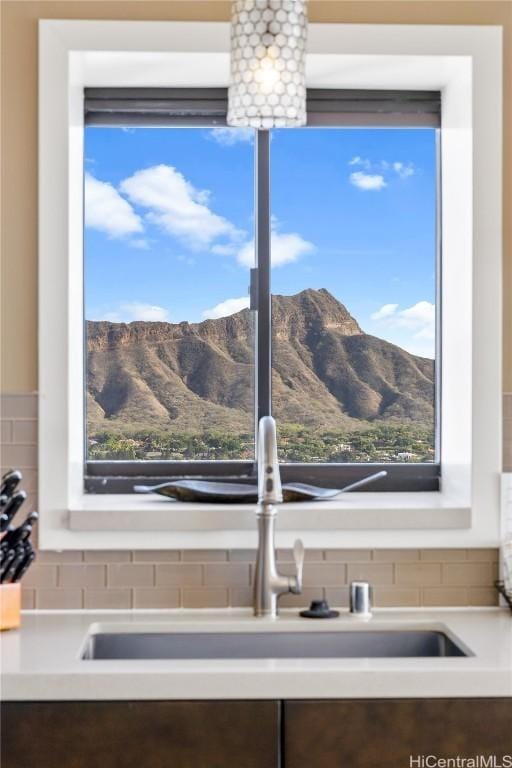 interior details with a mountain view, backsplash, and sink