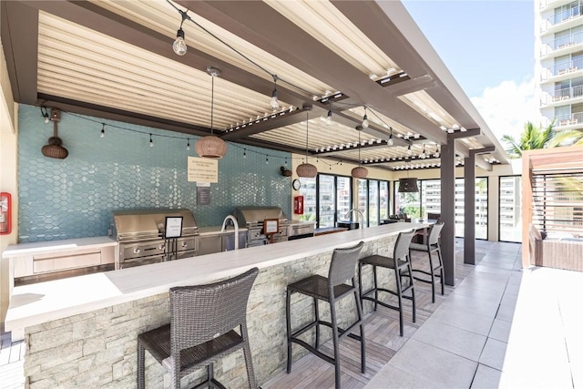 view of patio featuring an outdoor kitchen and a grill