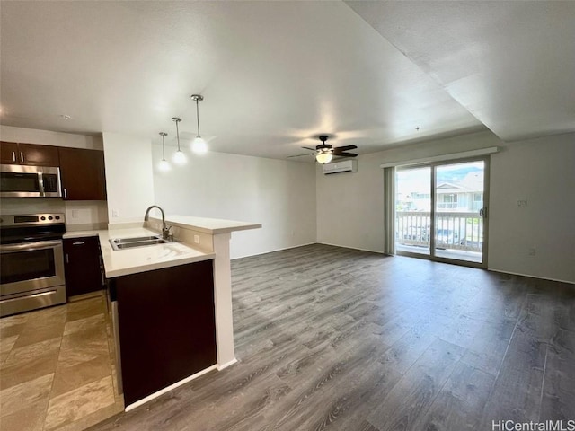 kitchen featuring sink, kitchen peninsula, decorative light fixtures, dark brown cabinets, and appliances with stainless steel finishes