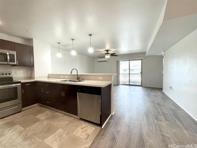 kitchen with pendant lighting, sink, ceiling fan, kitchen peninsula, and stainless steel appliances