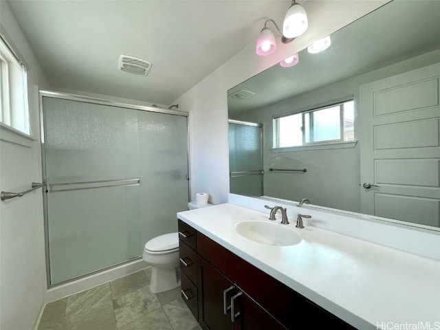 bathroom featuring an enclosed shower, vanity, and toilet