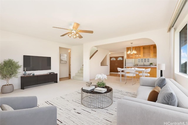 living room featuring ceiling fan with notable chandelier