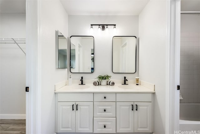 bathroom with vanity, tiled shower / bath combo, and hardwood / wood-style floors