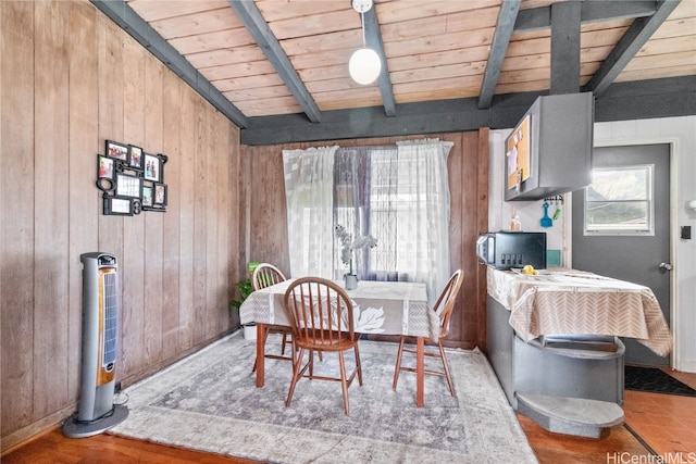 dining area featuring wood ceiling, lofted ceiling with beams, and wood walls