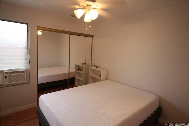 bedroom with cooling unit, dark wood-type flooring, a closet, and ceiling fan