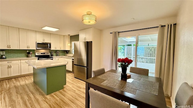 98-271 Kaonohi St Unit H2, Aiea, HI 96701 - kitchen with white cabinetry, appliances with stainless steel finishes, a center island, and light wood-type flooring