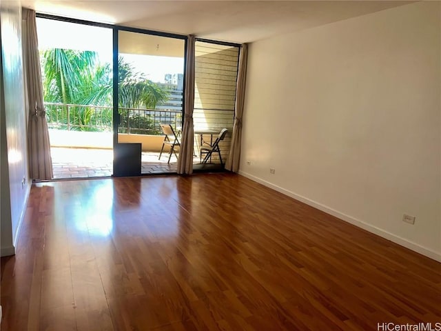 empty room with dark hardwood / wood-style flooring and floor to ceiling windows