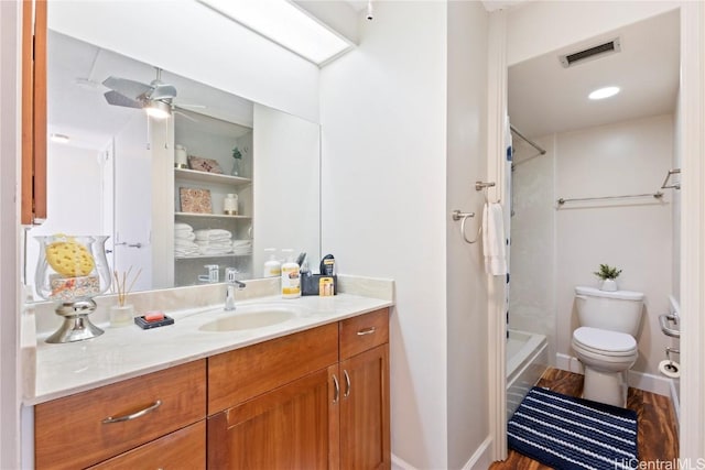 bathroom with vanity, a shower, ceiling fan, and toilet