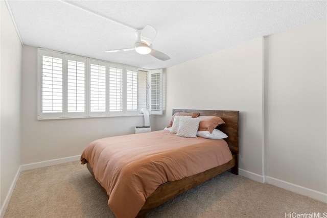 bedroom with light colored carpet, a textured ceiling, and ceiling fan