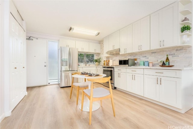 kitchen with decorative backsplash, light wood-type flooring, white cabinetry, and stainless steel appliances