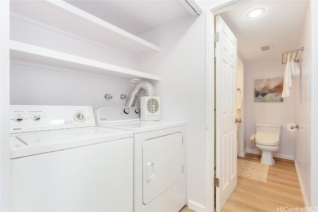 washroom featuring light hardwood / wood-style floors and washing machine and clothes dryer