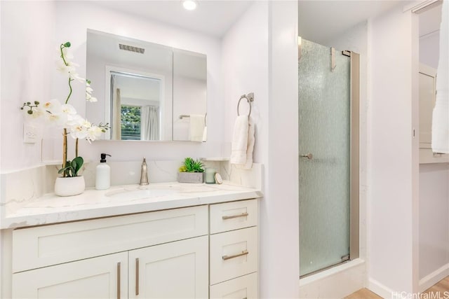 bathroom with vanity and a shower with shower door