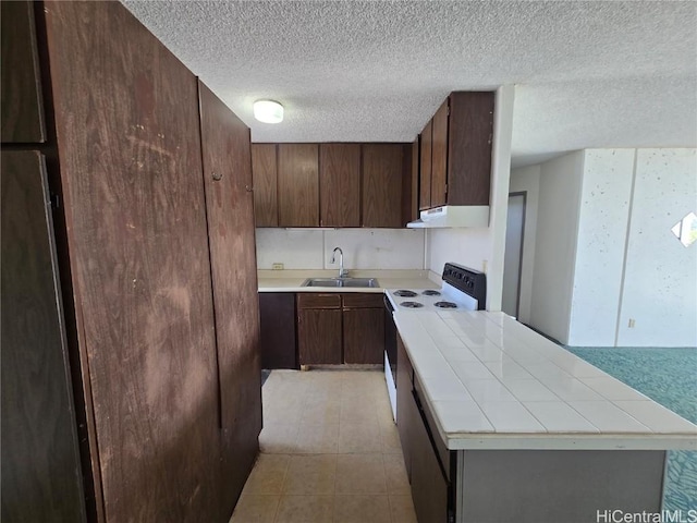 kitchen featuring a textured ceiling, dark brown cabinetry, white electric range, and sink