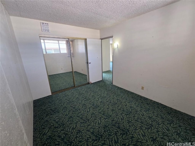 unfurnished bedroom with dark carpet and a textured ceiling