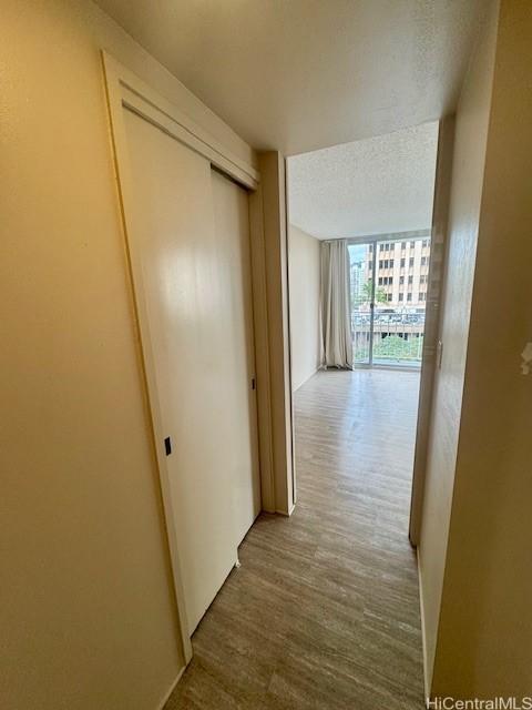 corridor featuring hardwood / wood-style floors and a textured ceiling