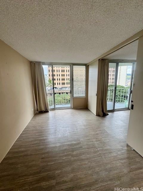 empty room featuring a textured ceiling and a wall of windows