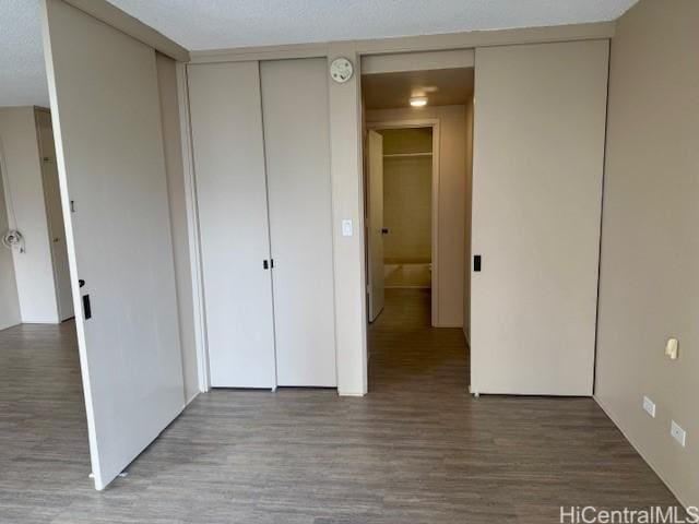 unfurnished bedroom with two closets and hardwood / wood-style floors