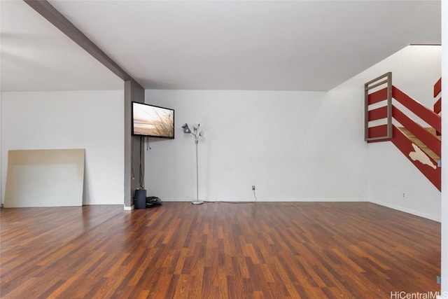 empty room with dark hardwood / wood-style flooring and beamed ceiling