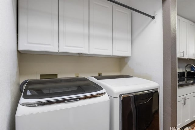 clothes washing area featuring sink, cabinets, and washing machine and clothes dryer