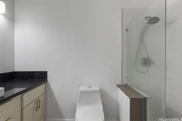 bathroom featuring vanity, a shower, and toilet