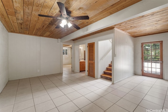 tiled spare room featuring wood walls, ceiling fan, crown molding, and wood ceiling