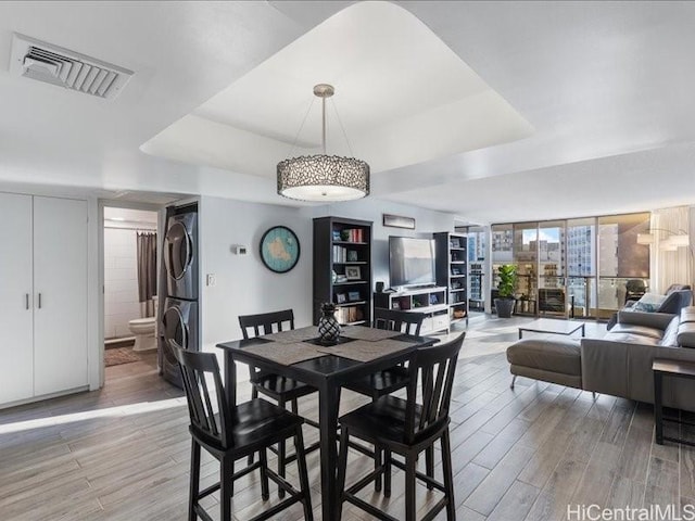 dining space featuring stacked washer / drying machine and expansive windows