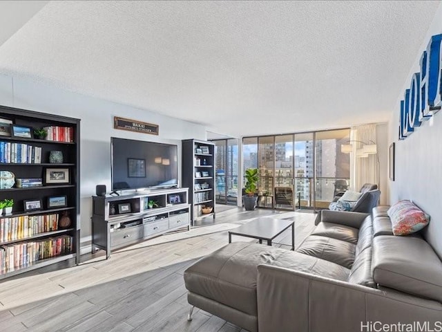 living room with floor to ceiling windows, a textured ceiling, and light hardwood / wood-style flooring