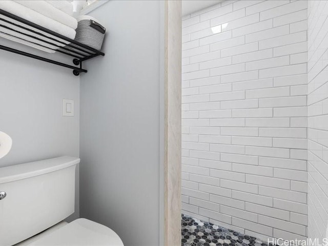 bathroom featuring toilet and tiled shower