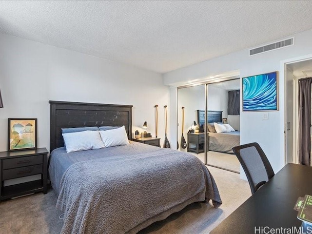 bedroom featuring a textured ceiling, a closet, and carpet