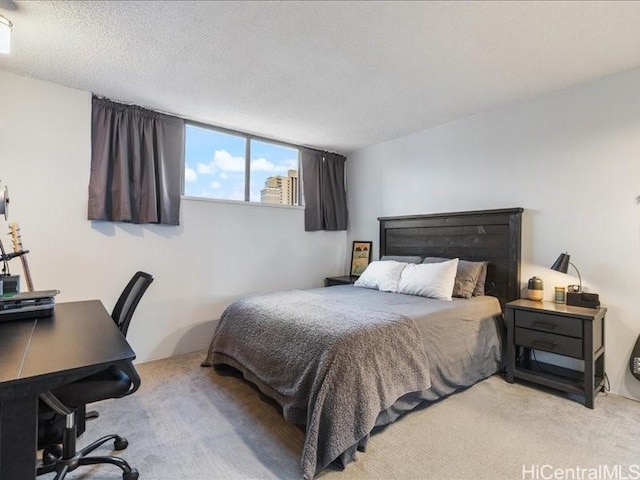 bedroom featuring light colored carpet and a textured ceiling