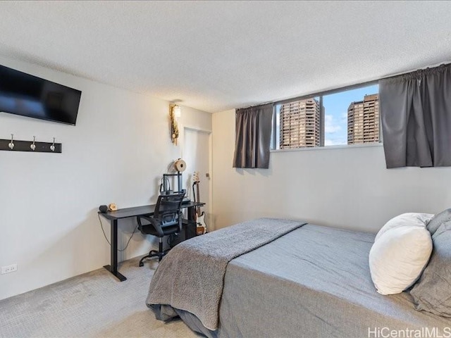 bedroom featuring a textured ceiling and light carpet